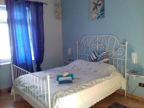 a white crib in a bedroom with blue walls at Casa Allorello in Laureana Cilento