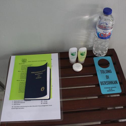 a table with a book and a bottle of water at Pondok Wisata dan Restoran Elim in Waingapu