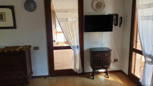 a room with a television and a door with a window at Mare a Santa Margherita in Pula