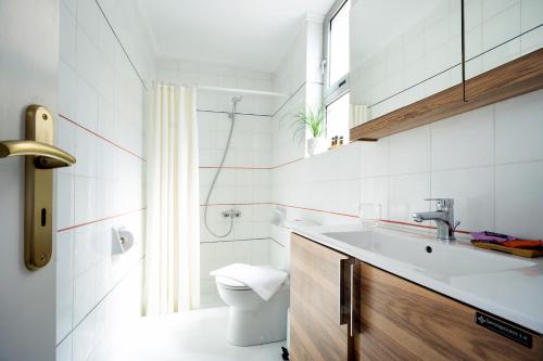 a white bathroom with a sink and a toilet at Metropolis House in Chania Town