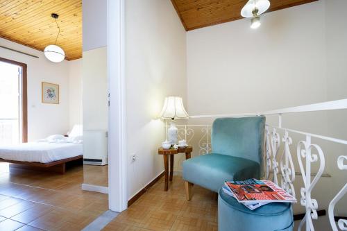 a bedroom with a blue chair and a bed at Metropolis House in Chania Town