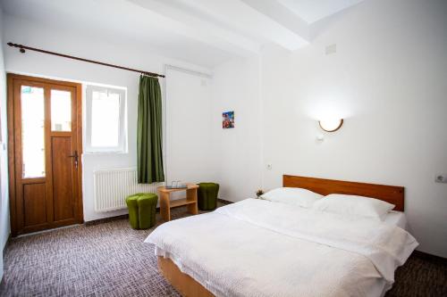een slaapkamer met een wit bed en een groen gordijn bij Complex Cazare Balea Transfagarasan in Cîrţişoara
