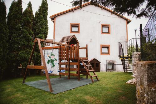 un parque infantil en el patio de una casa en El Requexu, apartamentos a 900 m de la playa de Poo, en Llanes