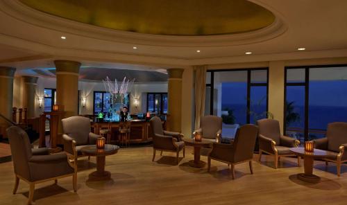 a waiting room with chairs and tables and a bar at Park Regency Sharm El Sheikh Resort in Sharm El Sheikh