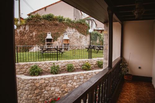 a balcony with a stone wall and a table and chairs at El Requexu, apartamentos a 900 m de la playa de Poo AR-0474-AS in Llanes
