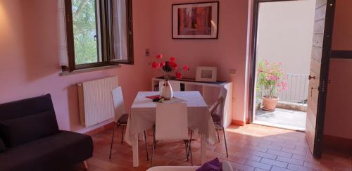 ein Wohnzimmer mit einem weißen Tisch und einem Stuhl in der Unterkunft House in Montegridolfo in Montegridolfo