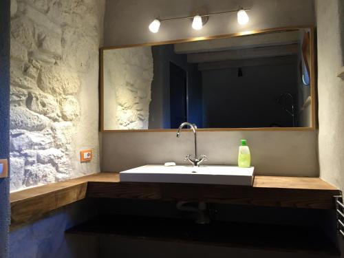 a bathroom with a sink and a mirror at Le Case Della Buca Agriturismo ed Agricampeggio in Seggiano