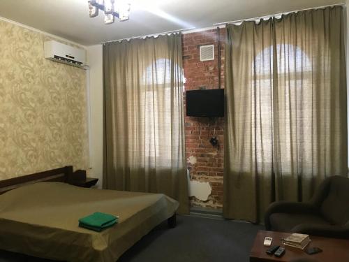um quarto de hotel com uma cama e uma parede de tijolos em Moskovs'kyi Avenue 41 em Kharkov