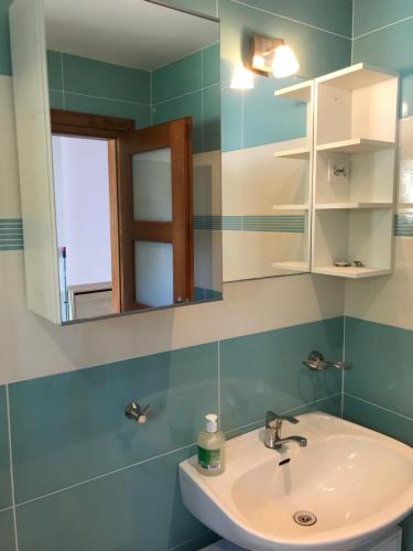 ein Bad mit einem Waschbecken und einem Spiegel in der Unterkunft Dom nad Jeziorem Zdworskim in Matyldów