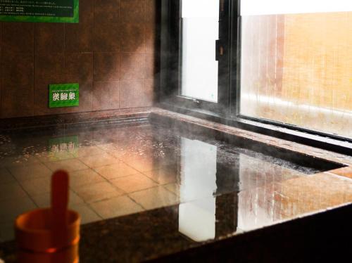 a room with rain on the floor and a window at Super Hotel Tokyo Kinshicho Ekimae in Tokyo