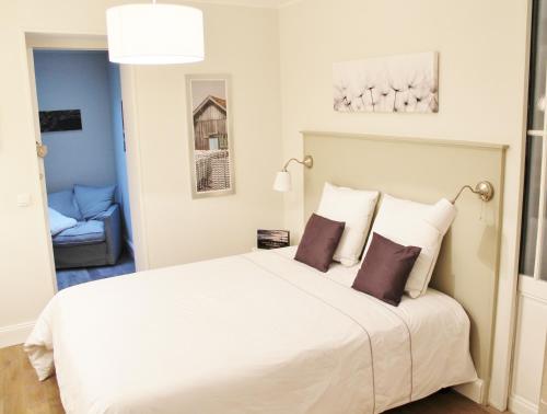 a bedroom with a large white bed with two pillows at L'Appart D'Oli et Tiane in Bordeaux