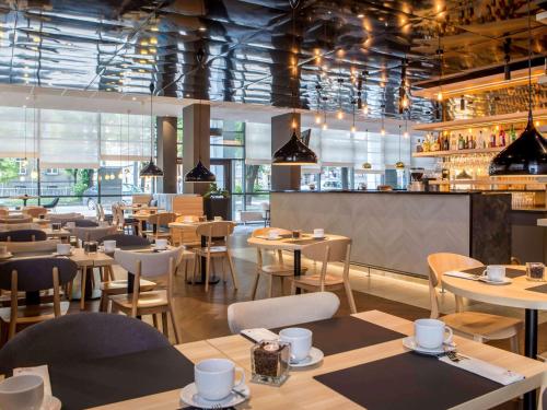 a restaurant with tables and chairs and a bar at Novotel Szczecin Centrum in Szczecin