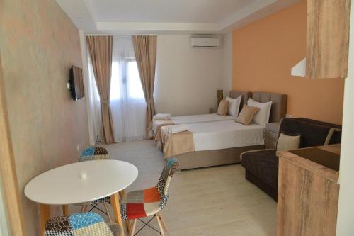 a hotel room with a bed and a table and chairs at Helada Apartments in Tivat
