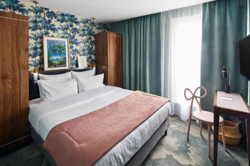 a hotel room with a bed and a desk and a window at Hotel Taylor in Paris