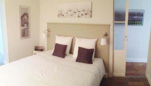 a bedroom with a large white bed with two pillows at L'Appart D'Oli et Tiane in Bordeaux