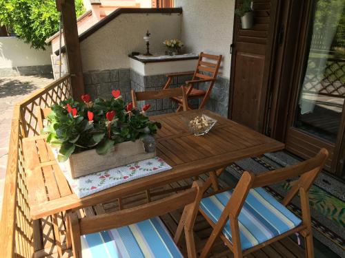 GiustinoにあるLa CRI Bed & Breakfastの木製テーブル(椅子付)と鉢植えのポーチ