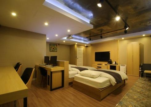 a bedroom with a bed and a desk and a television at No.1 New Yorker Hotel in Jinju