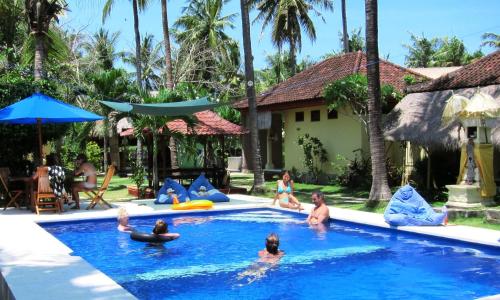a group of people in the swimming pool at a resort at Secret Garden Bungalows in Nusa Lembongan