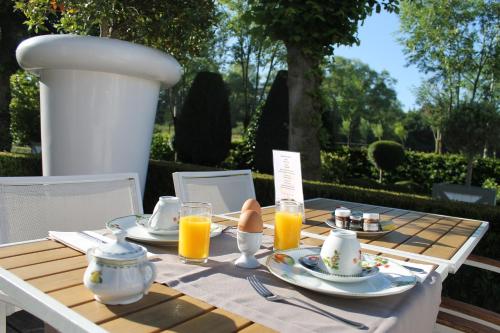 a wooden table with plates and glasses of orange juice at Marie Siska Boutique hotel in Knokke-Heist