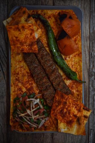 a plate of food with a pizza and vegetables at The Westist Hotel & Spa - Special Category in Istanbul