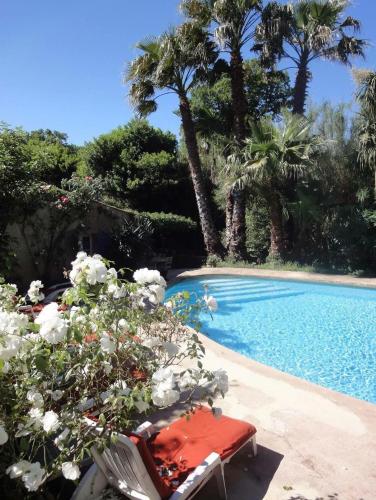 - une piscine avec une table rouge et quelques fleurs dans l'établissement Gite de l'Amandari - classé 3 etoiles Prefecture - piscine chauffée privative, terrasses et jardin, 5 minutes à pied du village, au Plan-de-la-Tour