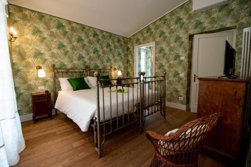 una camera con un letto in una stanza con carta da parati verde di Locanda Capolago a Colico
