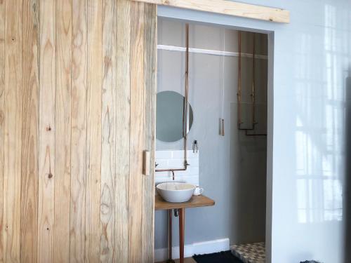 a bathroom with a wooden door with a sink at At The Loerie in Knysna