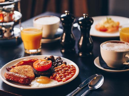 a table topped with plates of breakfast foods and coffee at Great Victoria Hotel in Bradford
