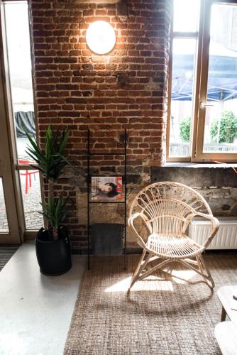 a chair sitting in a room with a brick wall at HI Liège Hostel in Liège