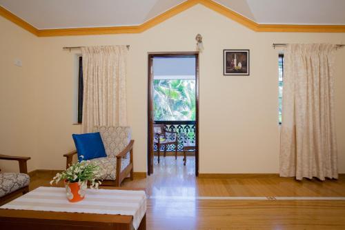 a living room with a couch and a table at Mistral Holidays Near Trinity Beach & Benaulim Beach in Benaulim