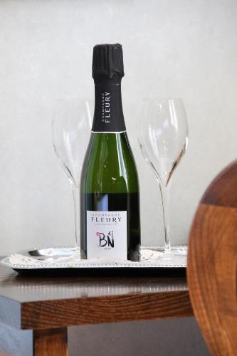 a bottle of wine on a plate with two wine glasses at Boutique hotel Shamon in Eeklo