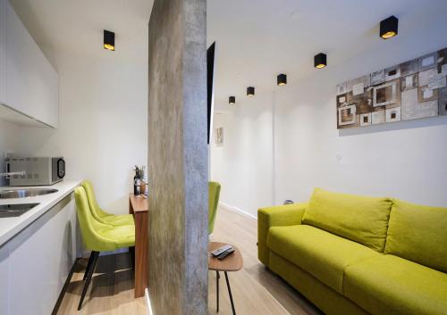 sala de estar con sofá verde y cocina en Apartman Toni, en Split