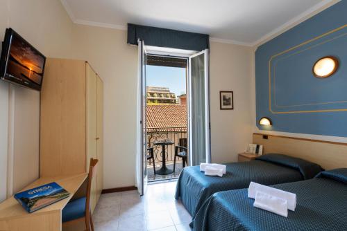 a hotel room with two beds and a balcony at Hotel Boston in Stresa