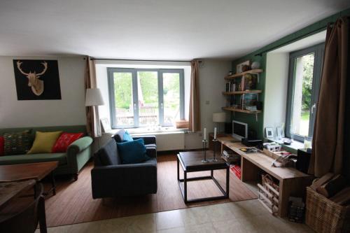 een woonkamer met een bank en een tafel bij Le Repere du Cerf in Herbeumont