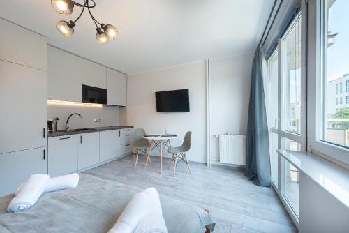 a bedroom with a kitchen and a table with chairs at IV apart in Gdynia