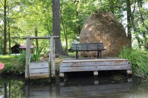 a bench sitting on a wooden bridge next to a large tree at Spreewaldhotel Garni Raddusch in Vetschau