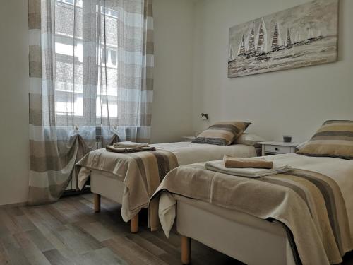 a bedroom with two beds and a window at Julia affittacamere in Trieste