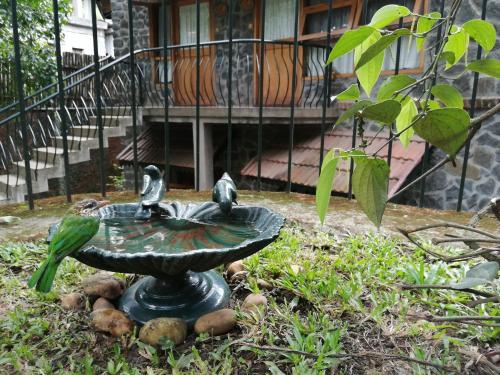 a bird bath with three birds on it in front of a building at Wildernest in Thekkady