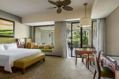 a bedroom with a bed and a dining room at Shangri-La Rasa Ria, Kota Kinabalu in Kota Kinabalu