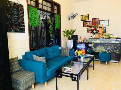 a living room with a blue couch and a glass table at Friendly House Hostel in Hue
