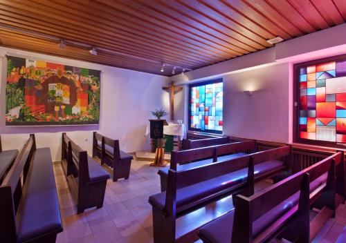 a church with benches and stained glass windows at Landhotel Karrenberg in Kirchberg