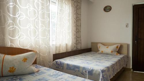 a bedroom with two beds and a window at Casa din Gradina in Eforie Sud