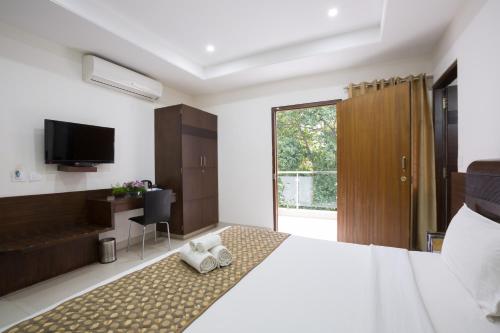 a bedroom with a large bed with towels on it at Sanctum Suites BEL Road Bangalore in Bangalore
