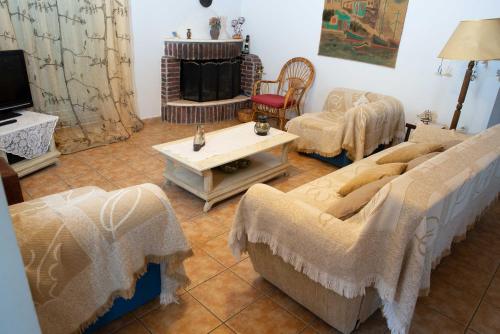 een woonkamer met banken en een tafel en een televisie bij Peloponnese Luxury Residence in Psathopirgos