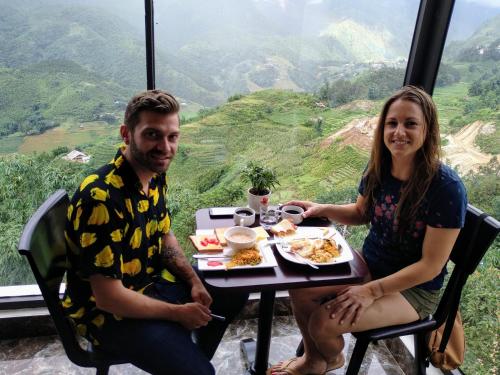 a man and a woman sitting at a table with food at Sapa Valley view hotel in Sa Pa