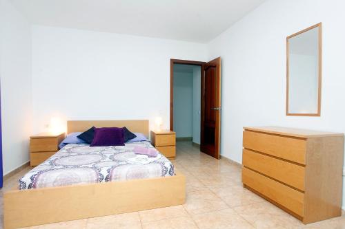 a bedroom with a bed and a dresser at Edificio Verde Parke in Corralejo