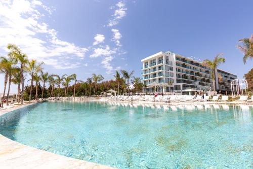 uma grande piscina em frente a um hotel em BLESS Hotel Ibiza - The Leading Hotels of The World em Es Cana