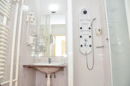 a bathroom with a sink and a shower at Hotel Barátság in Hajdúszoboszló