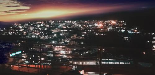 a view of a city at night with lights at Woodland Hill Stay in Shillong