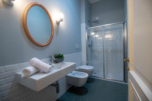bagno con lavandino, servizi igienici e specchio di Locanda Capolago a Colico